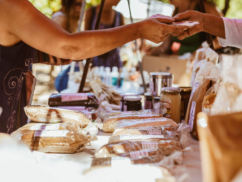 person buying goods at farmers market